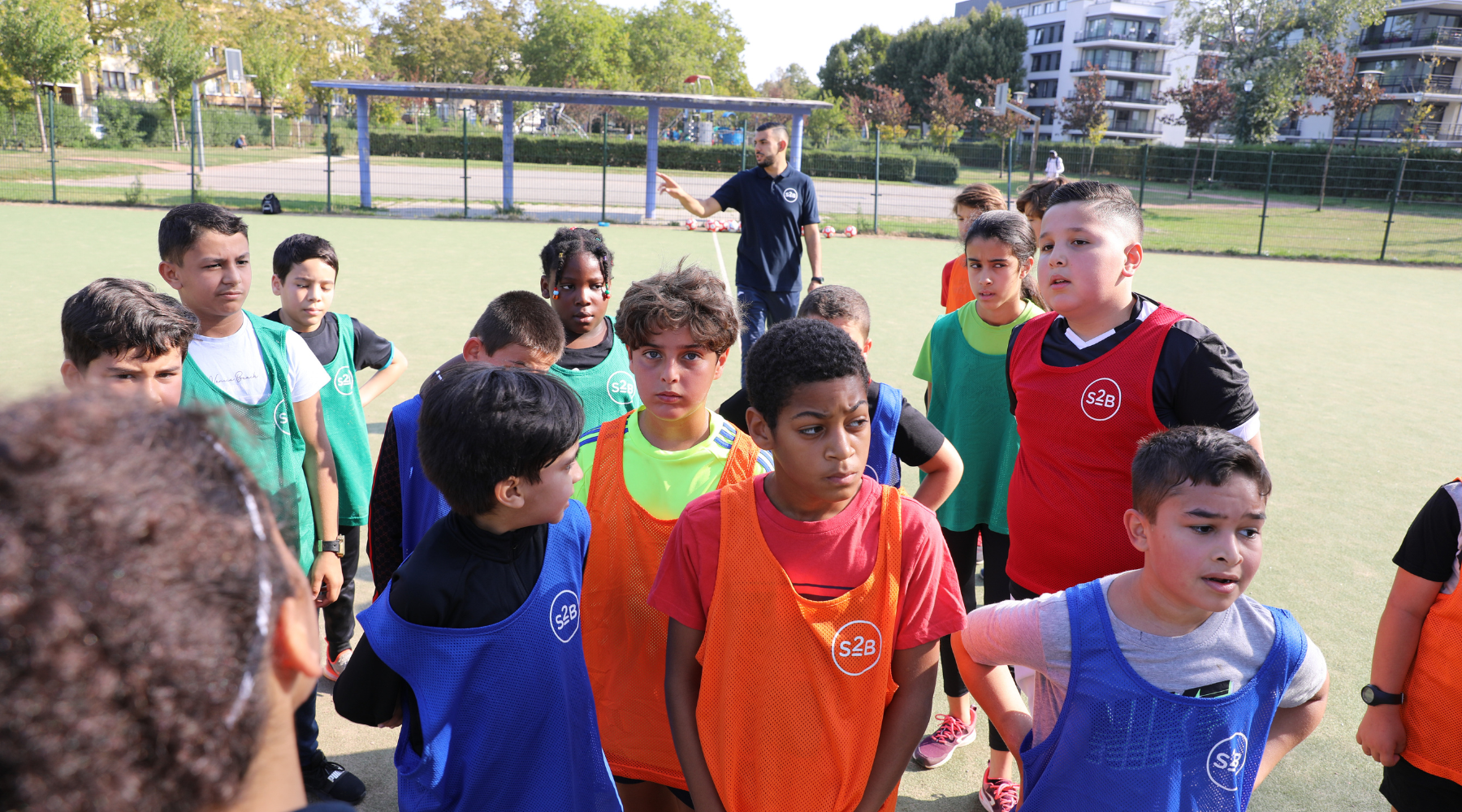 Young footballers listening to their coach during a free football training session by Sport2Be